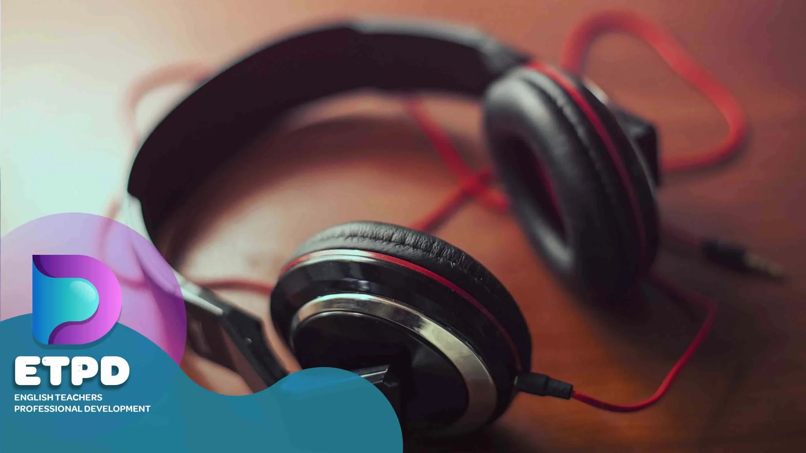 The pictures shows a pair of headphones with a red wire on a wooden table with logo of ETPD